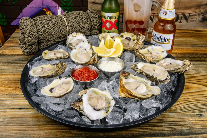 Oysters on the half shell arranged on ice with lemon and sauces